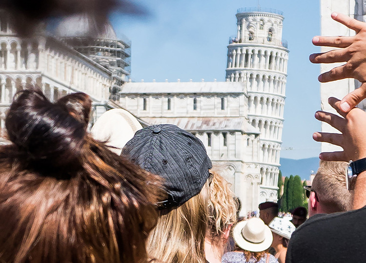 Topdeck Travel tour group heading to the Piazza del Duomo, with the Leaning Tower of Pisa in the background.