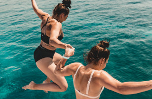 Two Topdeck travelers jumping into the clear waters of the Adriatic sea on a sailing trip in Croatia.