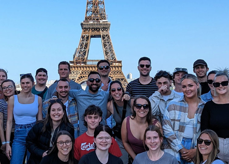Topdeck Get Social tour group posing for a phot in front of the Eiffel Tower in Paris.