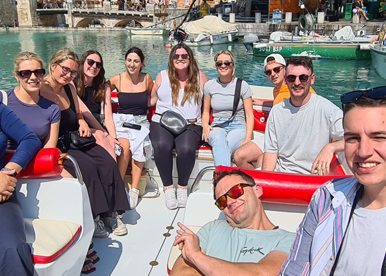 Topdeck travel group posing for a photo op on a boat during their Play and Pause tour.