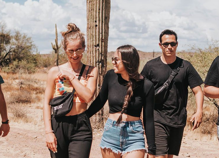 Group standing in the Arizona desert in front of a cactus.